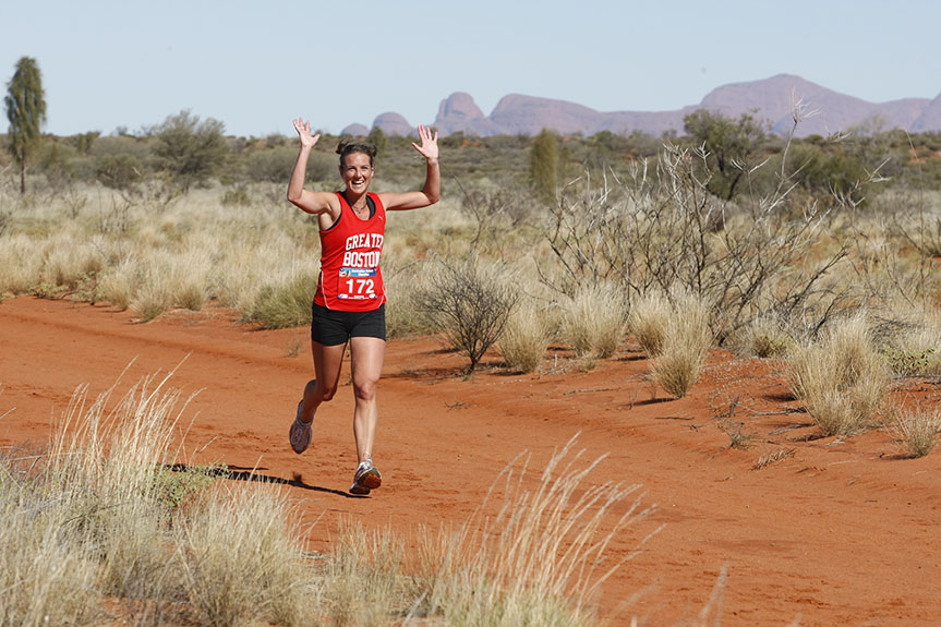 A Woman smiles while running in the Australia Outback Marathon