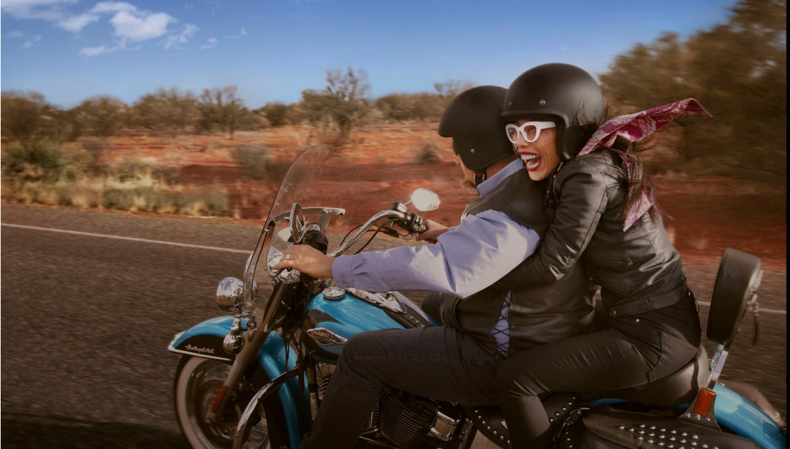 woman riding on the back of a Harley motorcycle